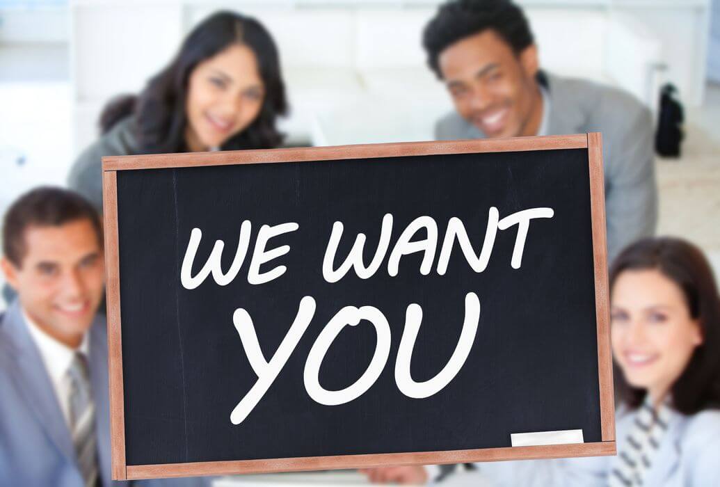 meinkarrierestart.at Vier Personen im Business-Outfit sitzen lächelnd zusammen, davor steht eine Tafel mit der Aufschrift „WIR WOLLEN DICH“ in großen weißen Lettern – und sind bereit, ihre besten Bewerbungstipps für Ihre nächste Bewerbung zu verraten.